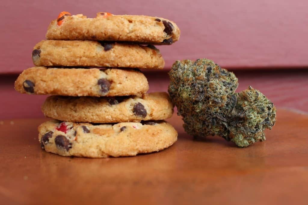 Five cookies with a cannabis bud