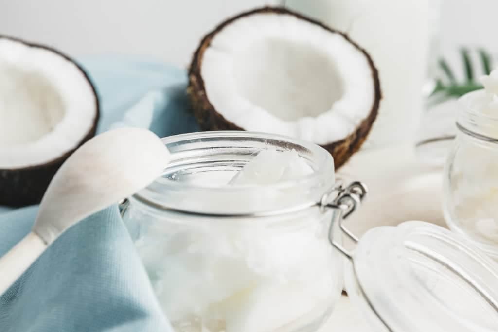 Jar of coconut meat with half opened coconut shell