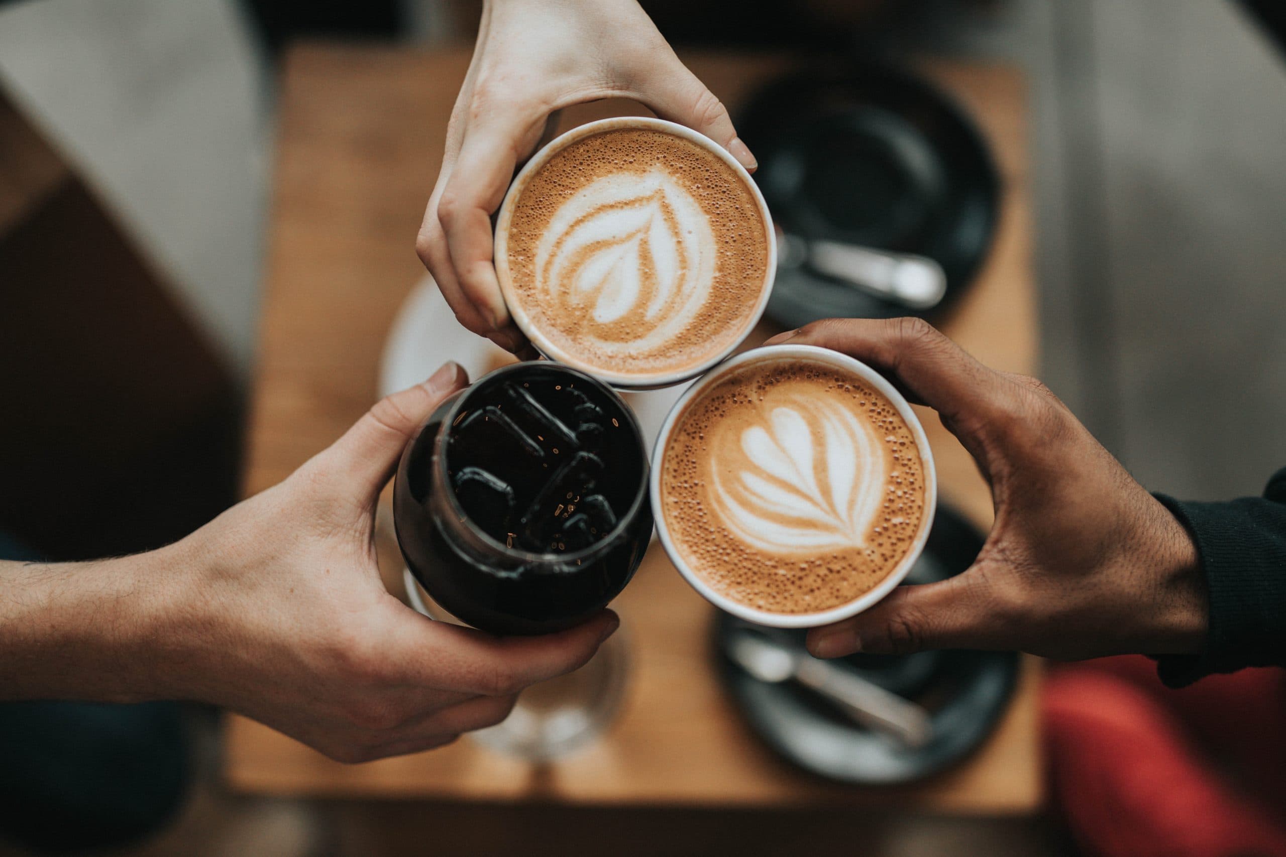 Friends clinging cups of coffee together