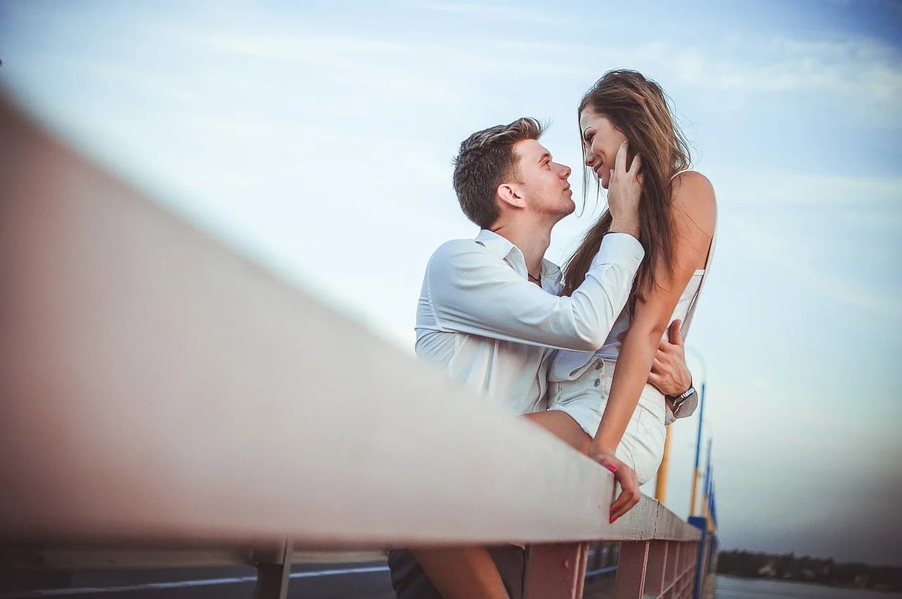 A couple embraces on a pier near the lake, by UpFree via Pixabay