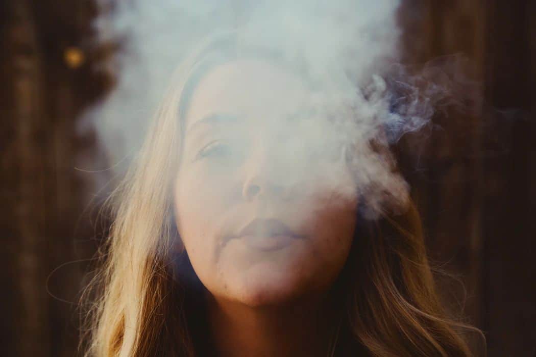 A woman exhales vapor, by Giorgio Trovato via Unsplash