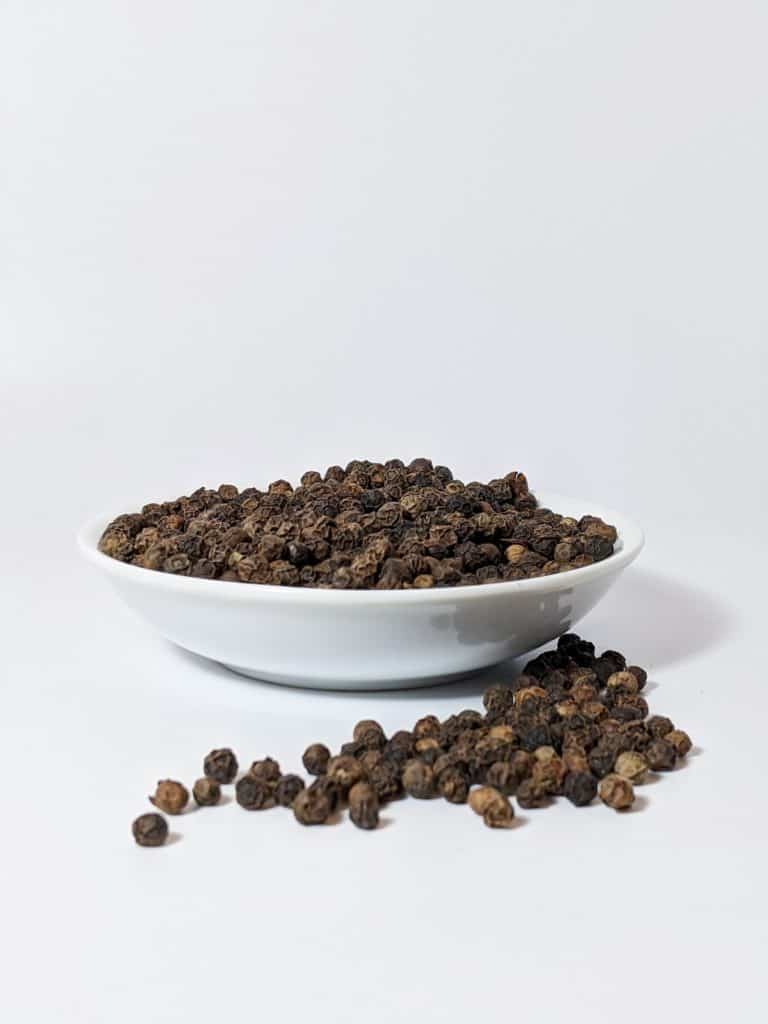 Black peppercorn in white bowl