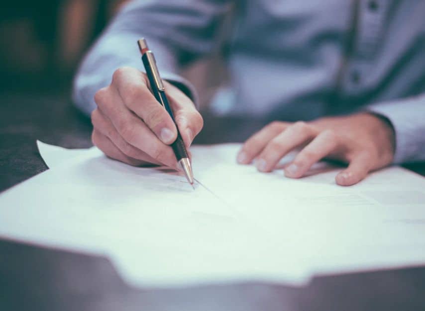 Man writing a letter, hopefully to Congress in support of cannabis legislation, by Scott Graham via Unsplash