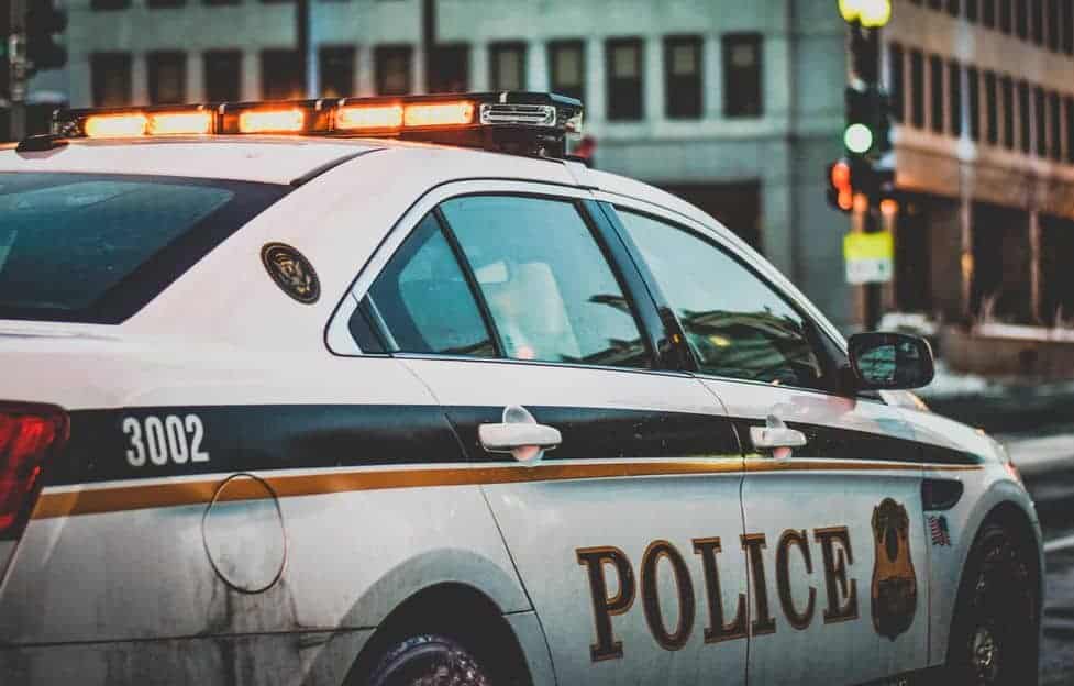 A police car with lights on, by Matt Popovich via Unsplash