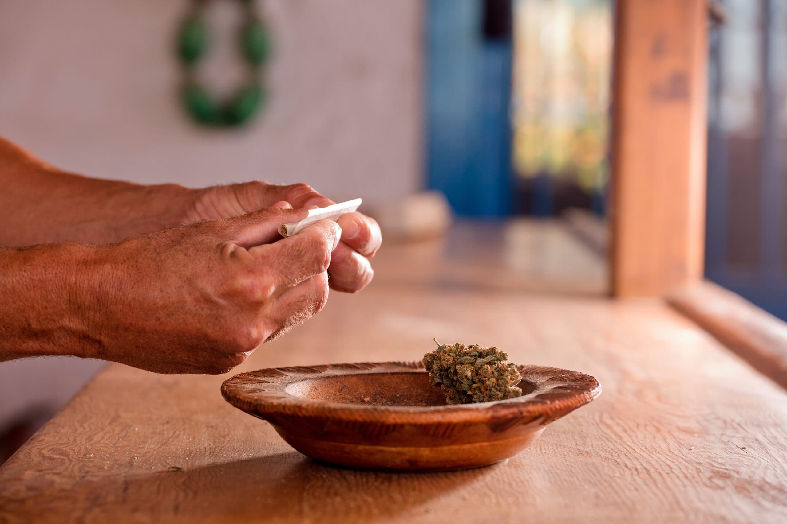 man hands prepare marijuana cigar at home