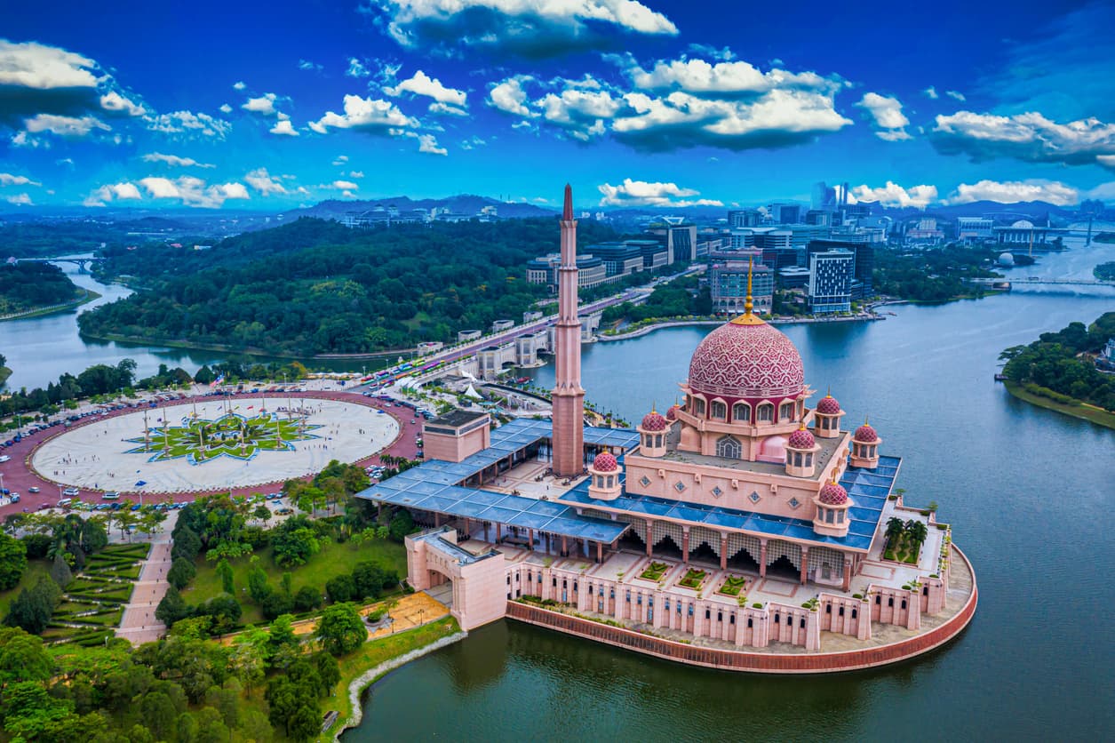 Aerial View Of Putra Mosque with Putrajaya City Centre with Lake at sunset in Putrajaya, Malaysia.