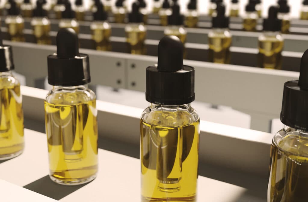 Large amount of CBD oil bottles in rows on production lines inside a pharmaceutical factory.