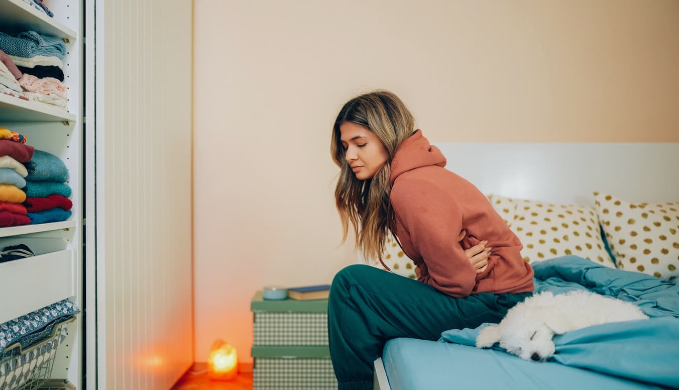 Young woman with painful menstruation resting in bed