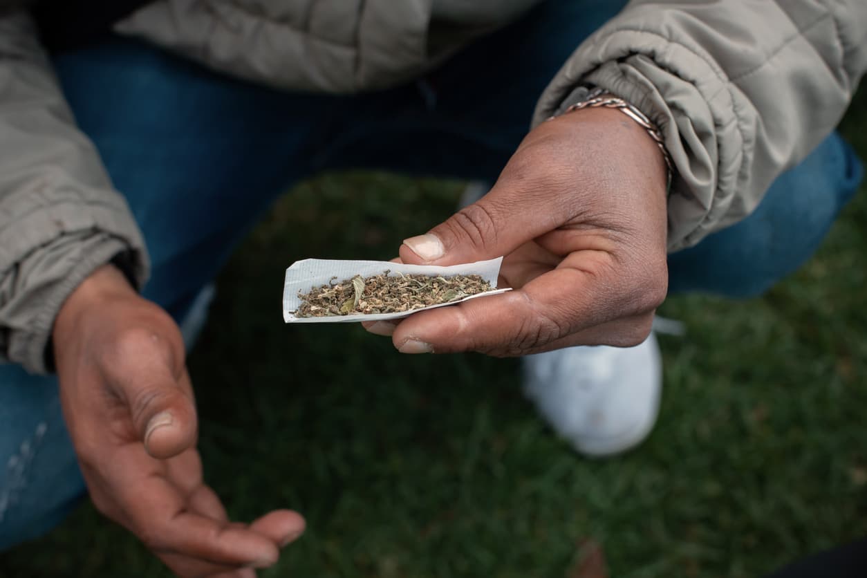 young man rolling a very big joint