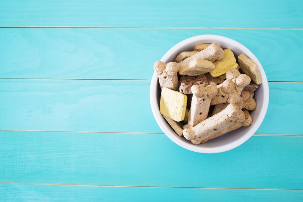 Dog treats in a bowl on wooden table