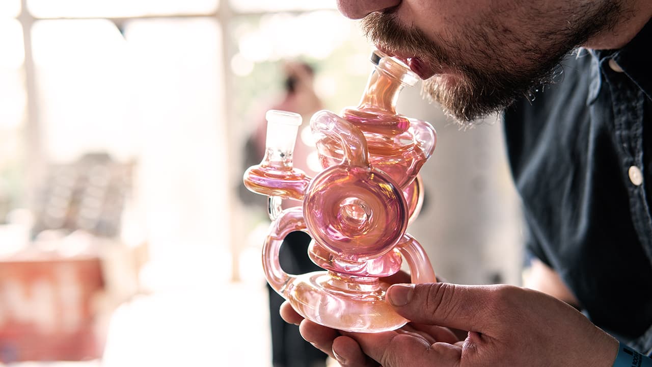 glass bong close-up in mans hands in process