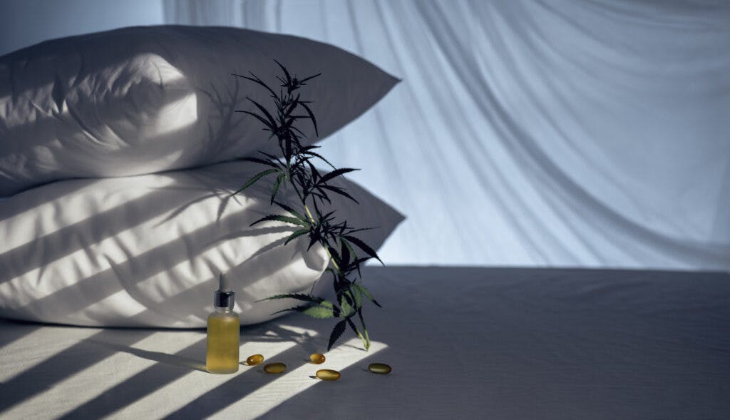 Evening bedroom with cbd oil, capsules and a cannabis branch. Melatonin production, concept to combat sleep disorders