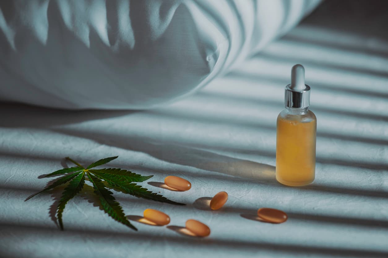 Evening bedroom with cbd oil, capsules and a cannabis branch. Melatonin production, concept to combat sleep disorders