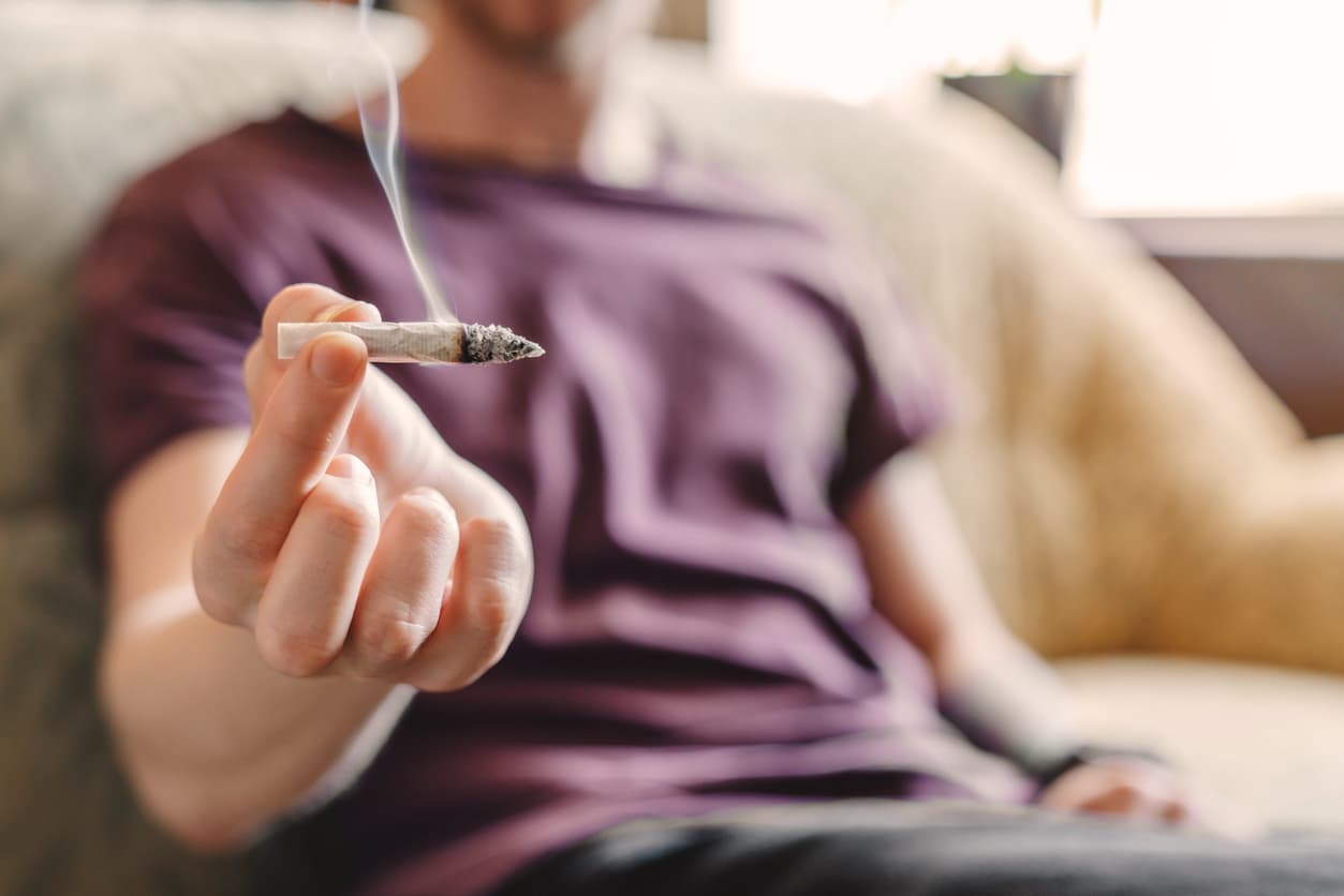 Image of a young man passing a cannabis joint