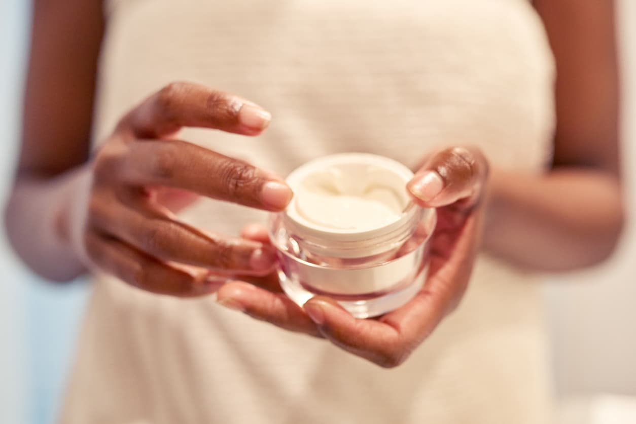 Cropped shot of a woman holding a skincare product in her hands