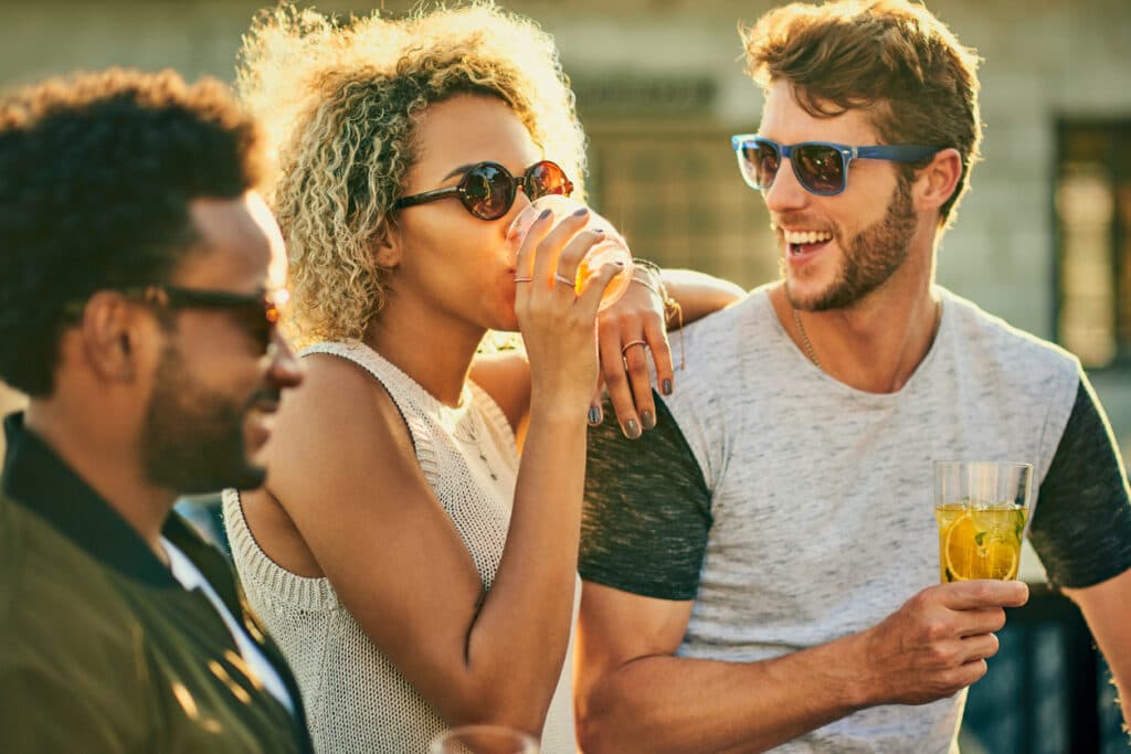 Cropped shot of a group of young friends having a drink and spending the day outside on a rooftop