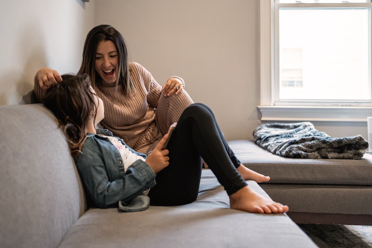 Mother and daughter together at home using a tablet