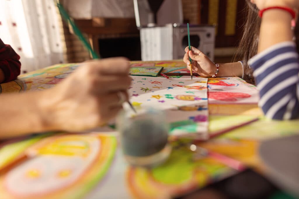 Joyful mother, helping her daughter to do art and crafts 