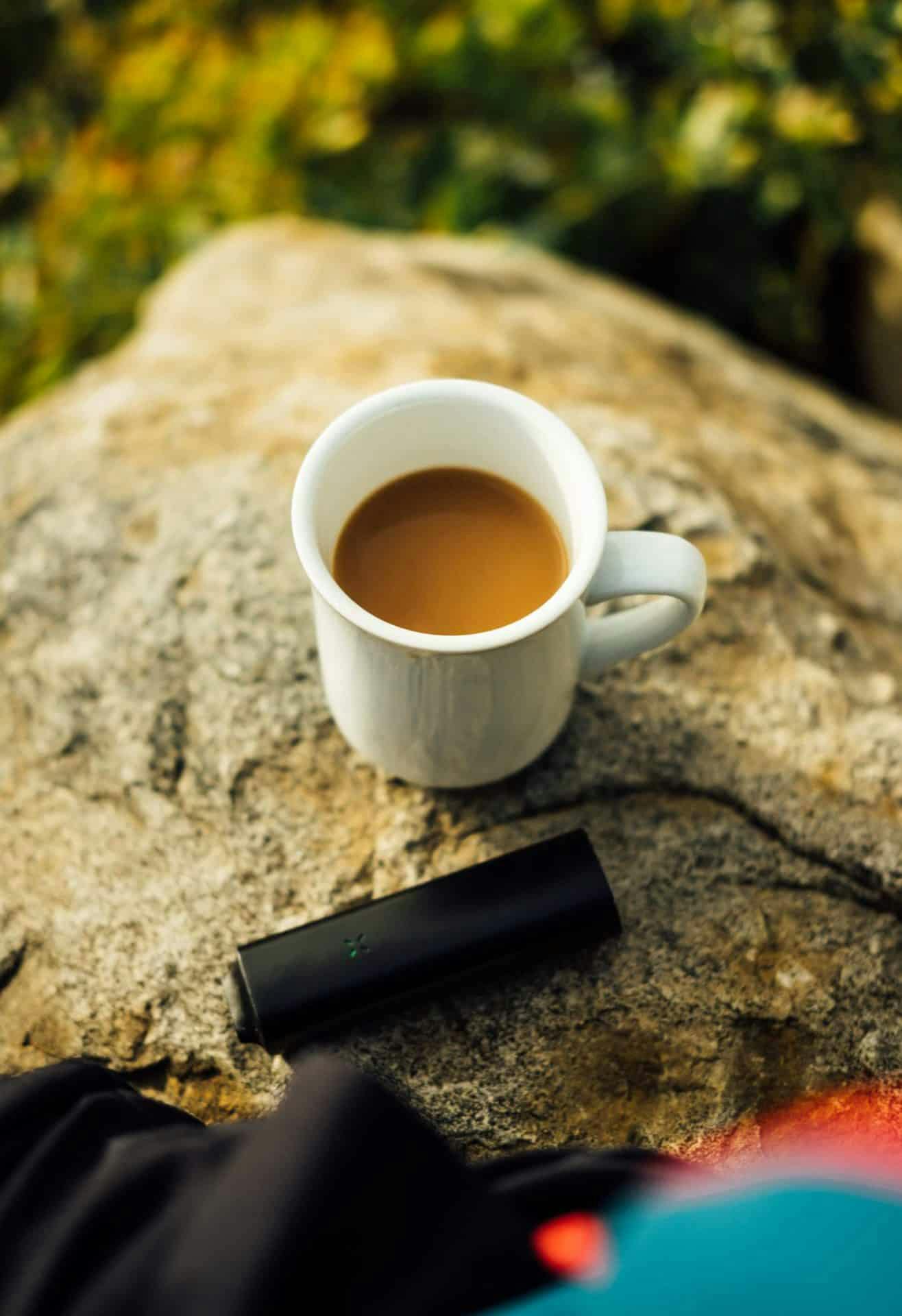 picture of coffee mug and cannabis vaporizer on a rock