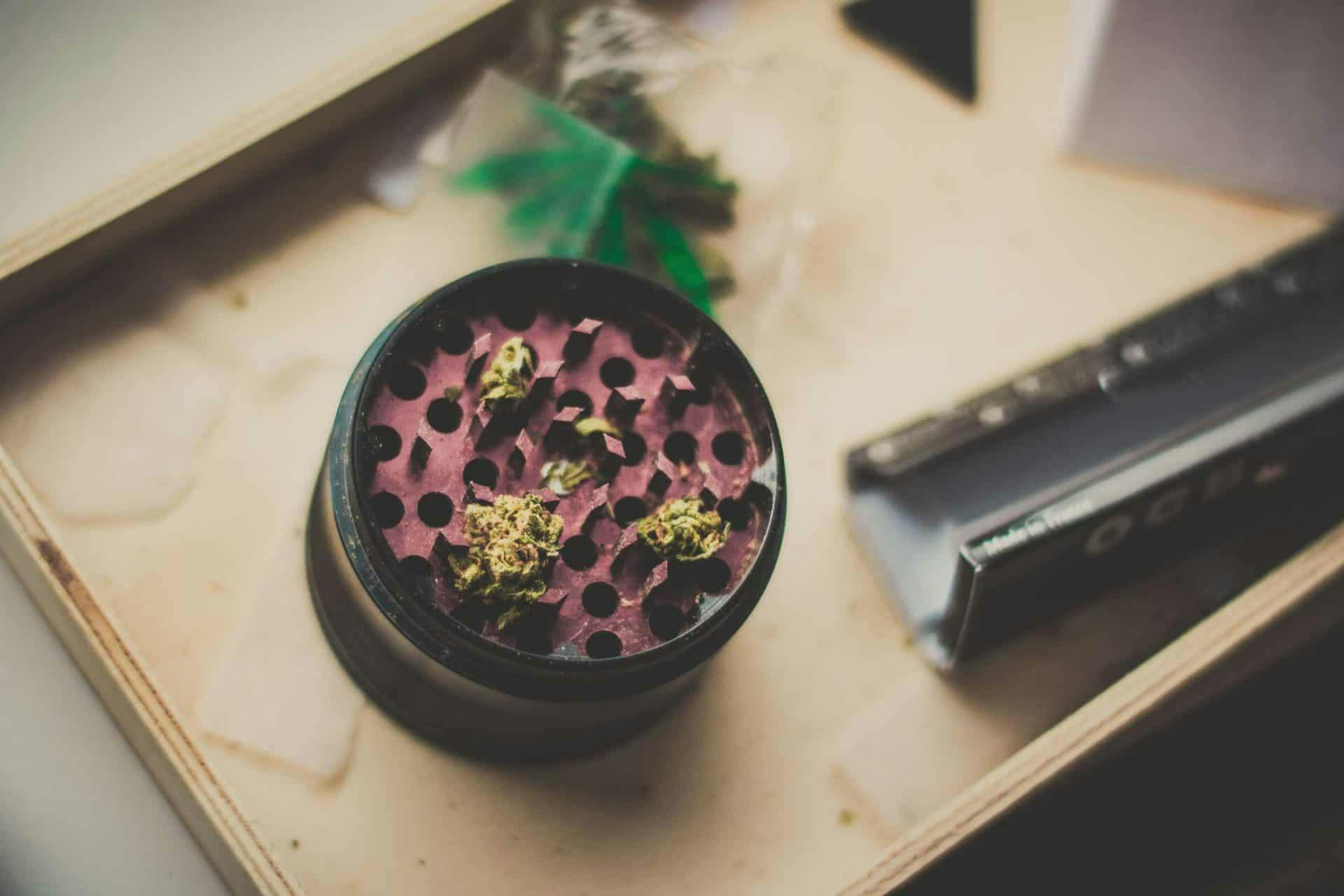 Photo of a weed grinder next to rolling papers.