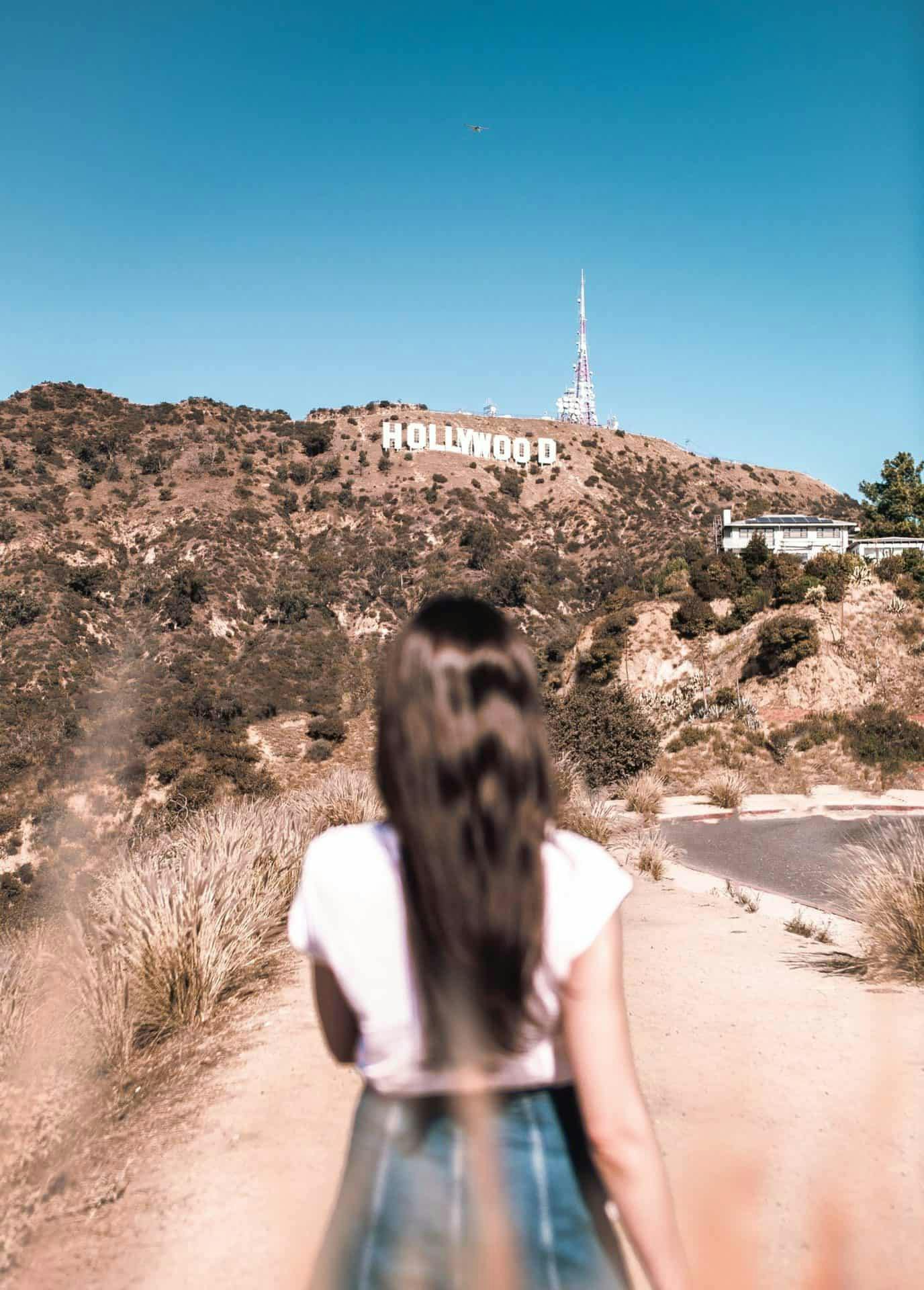 Photo of a woman in front of the Hollywood sign