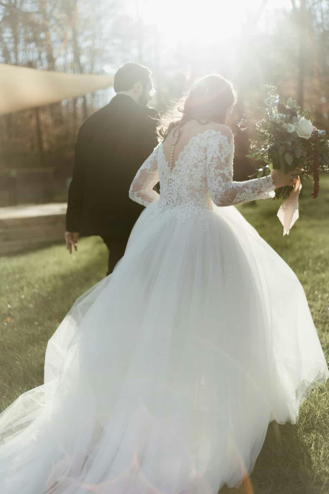 Photo of a bride and groom holding hands and walking