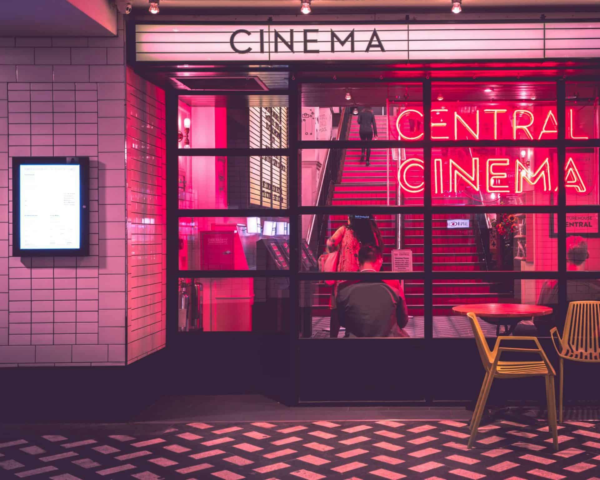 photo of a theater with a central cinema neon light