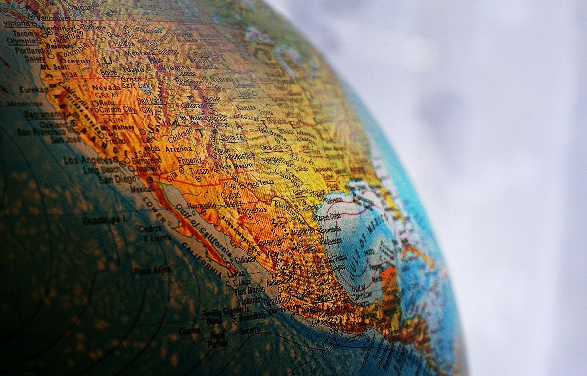 A globe containing a map of America, by Suzy Hazelwood via Unsplash