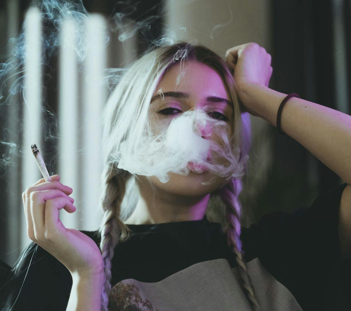 A woman smokes a joint, by Damian Barczak via Unsplash