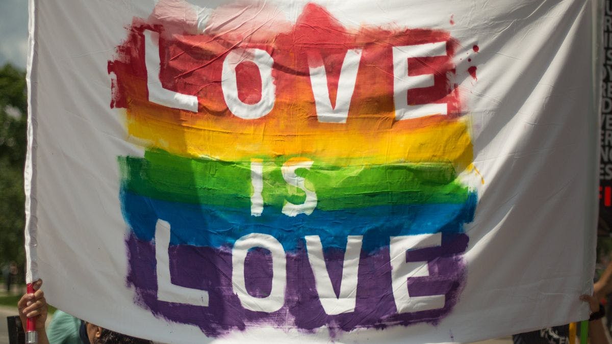 A rainbow flag with the words "Love is Love', by 42 North via Pexels