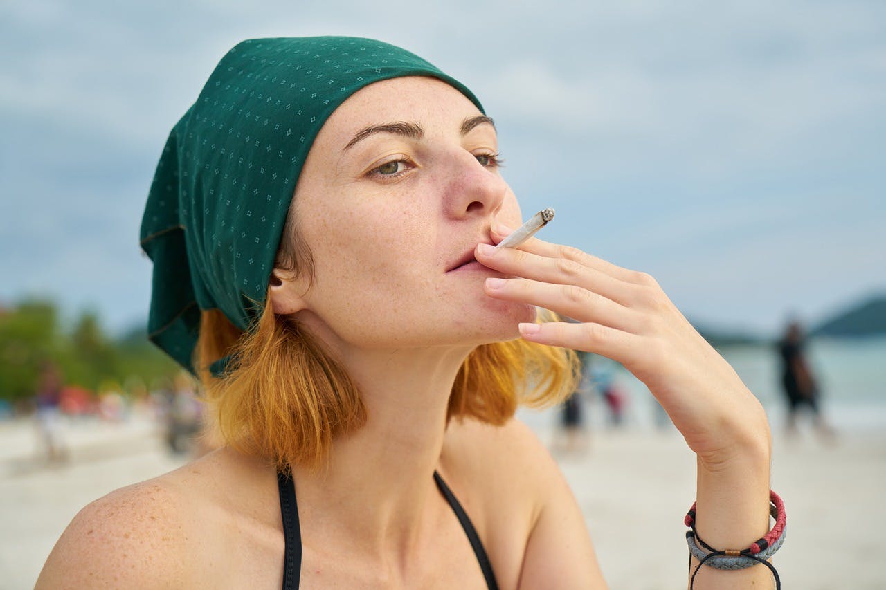 A young woman smokes a joint, by Engin Akyurt via Unsplash