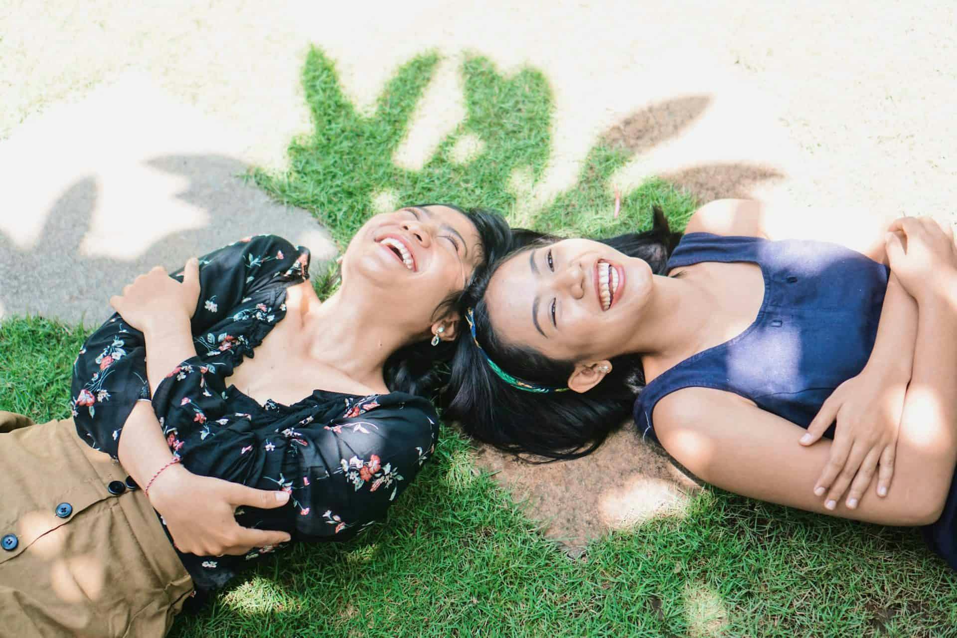 two girls laughing on ground