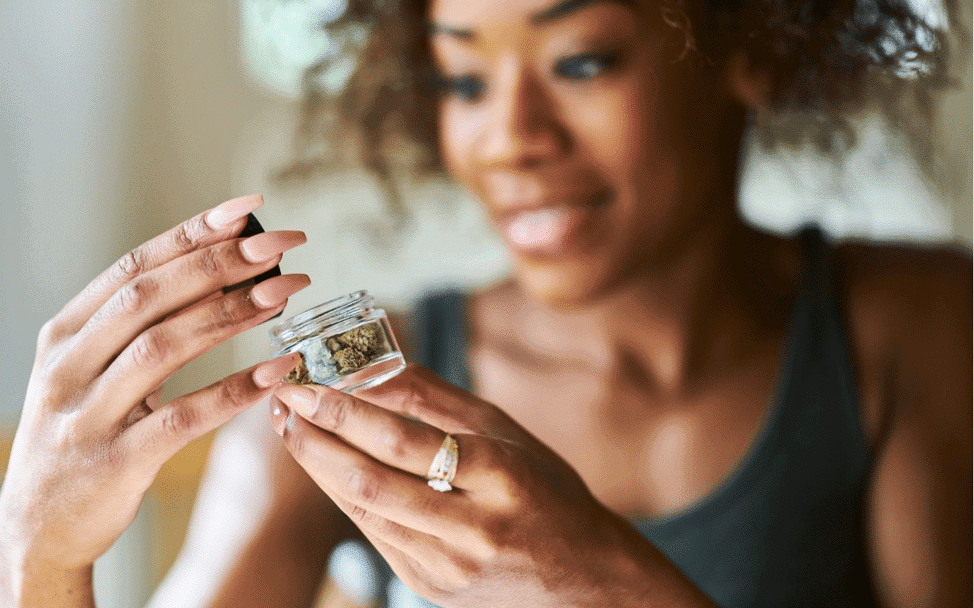 Woman looking a cannabis in a glass jar