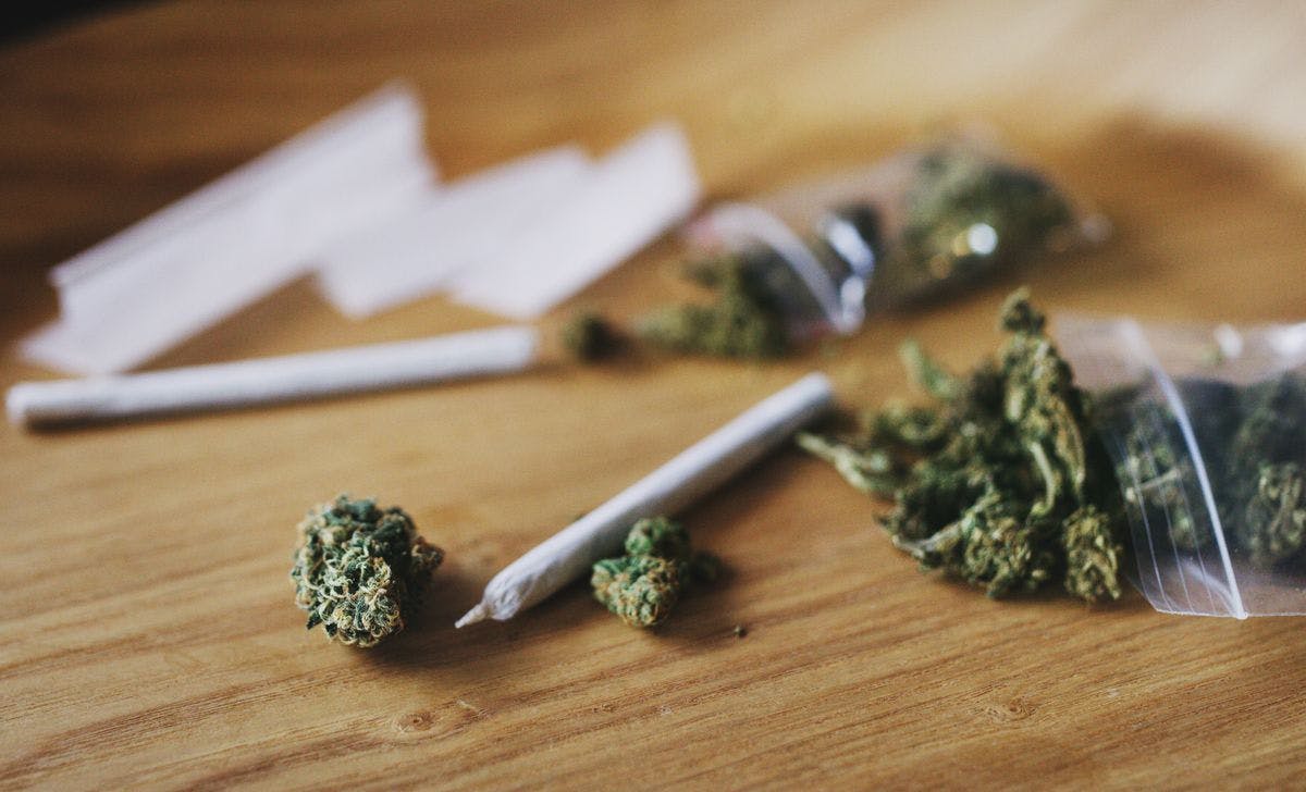 Shot of dried hemp or weed buds and a rolled joint, by gradyreese via iStock