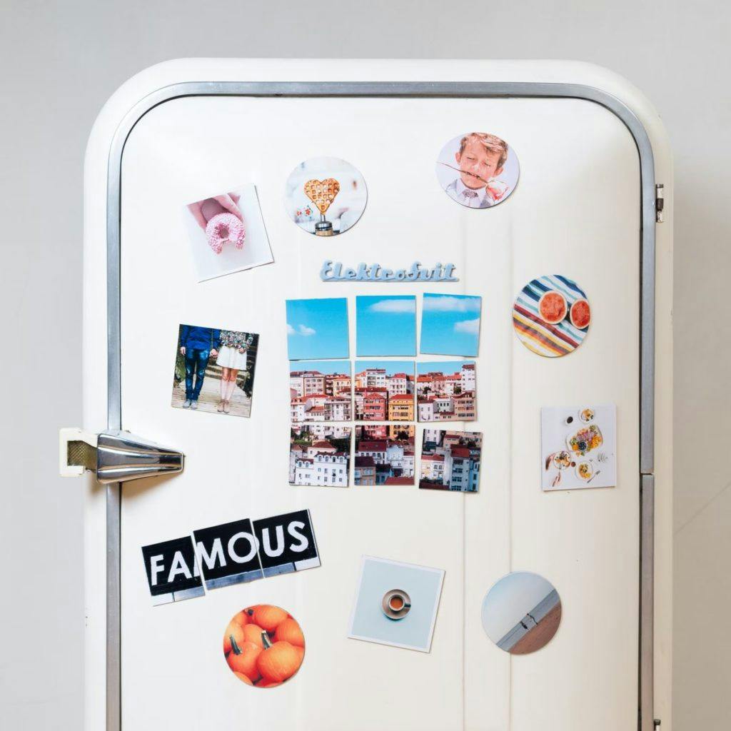 A vintage refrigerator, covered in stickers, by Squared.One via Unsplash
