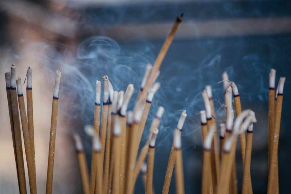 Incense sticks, burning and producing smoke, by Milada Vigerova via Unsplash