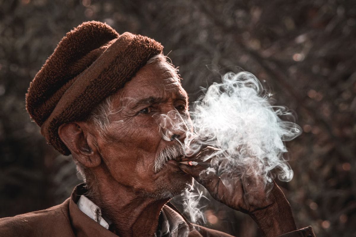 An elderly man smokes a joint, by Prince Patel via Unsplash