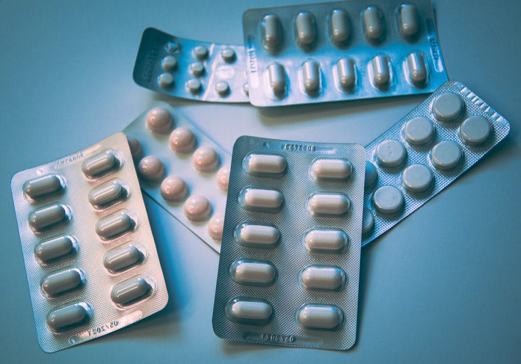 Assorted pill packs & supplements, by Christine Sandu via Unsplash