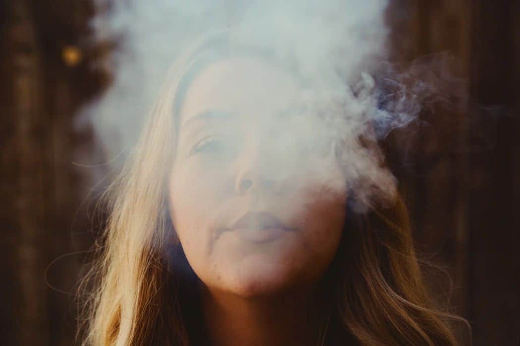 A woman exhales vapor, by Giorgio Trovato via Unsplash