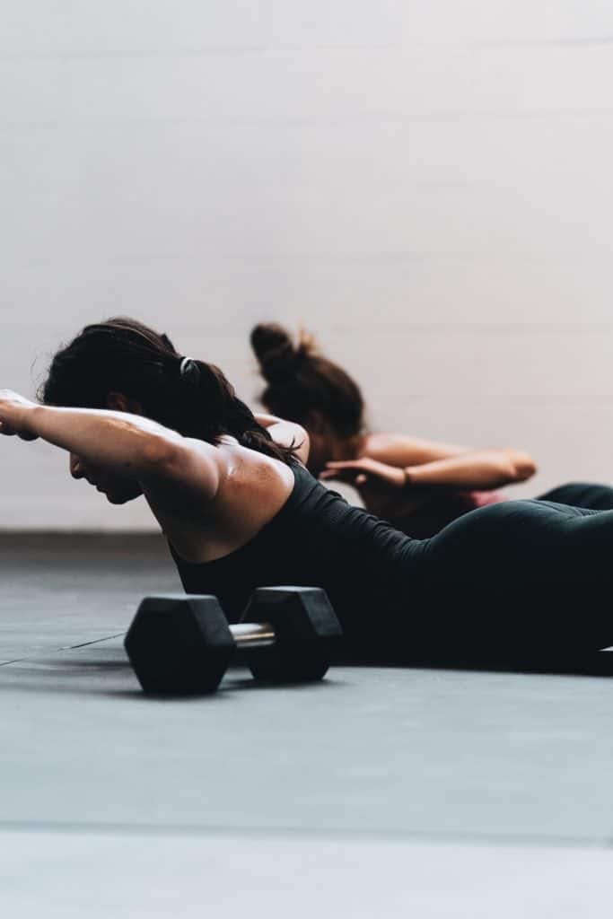Two women laying on their belly doing core exercises