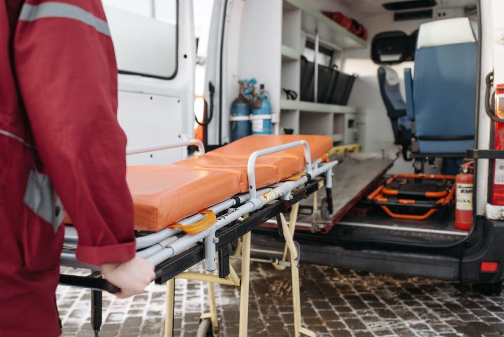 A man loads a stretcher into an ambulance, by Pavel Danilyuk via Pexels