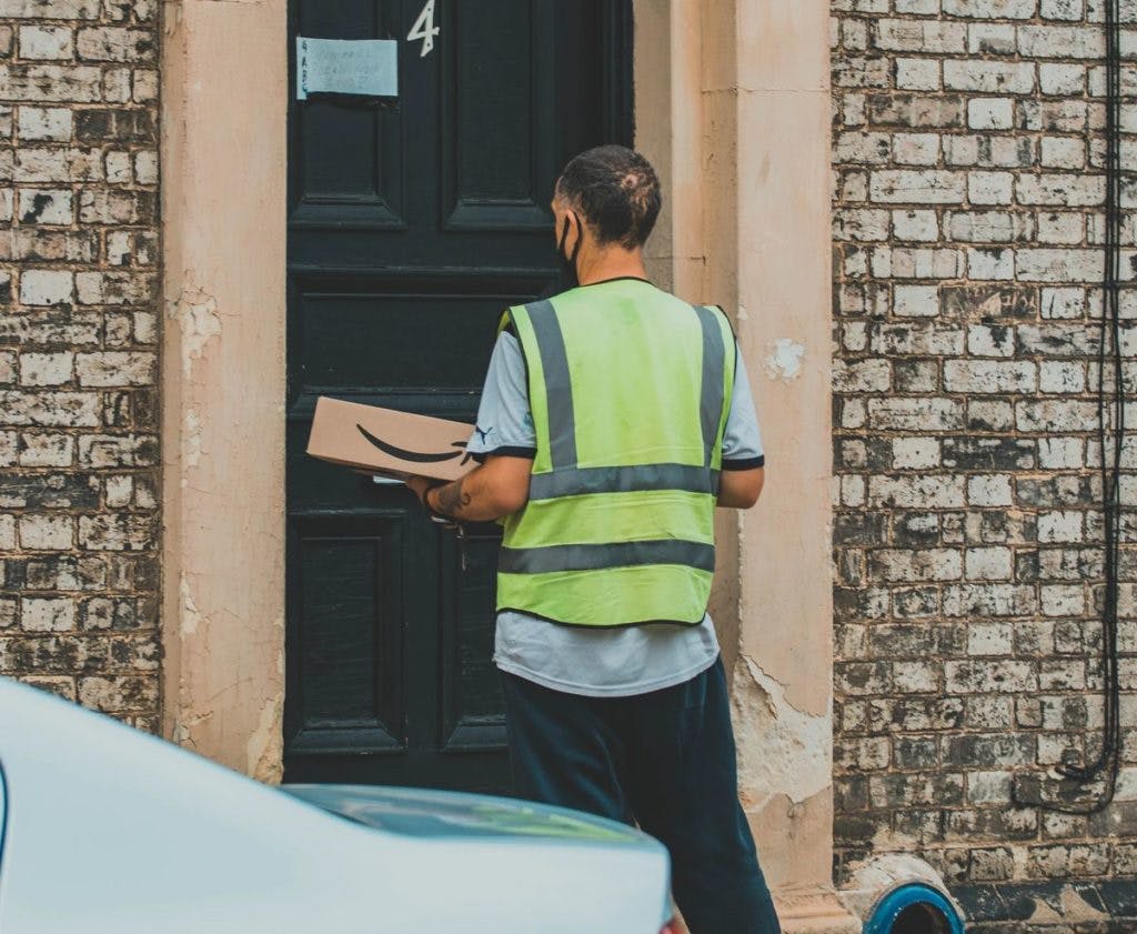 An Amazon delivery driver making a delivery, by Super Straho via Unsplash