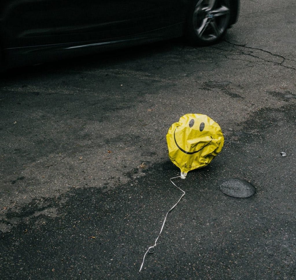 A sad balloon, lying on the pavement