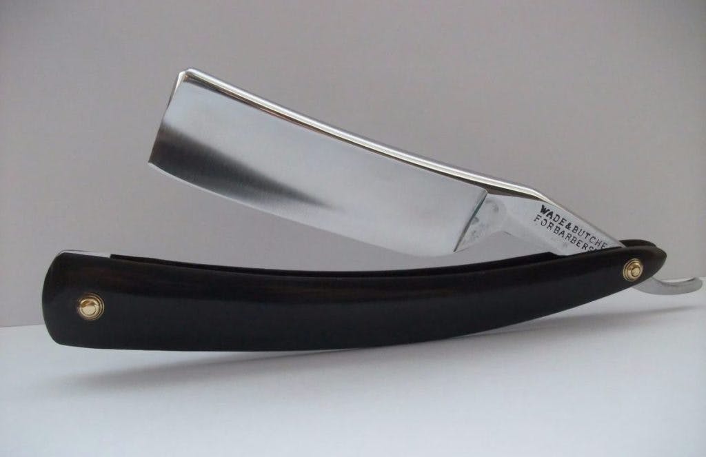 A straight-edged shaving razor, by Allyson Carter via Unsplash