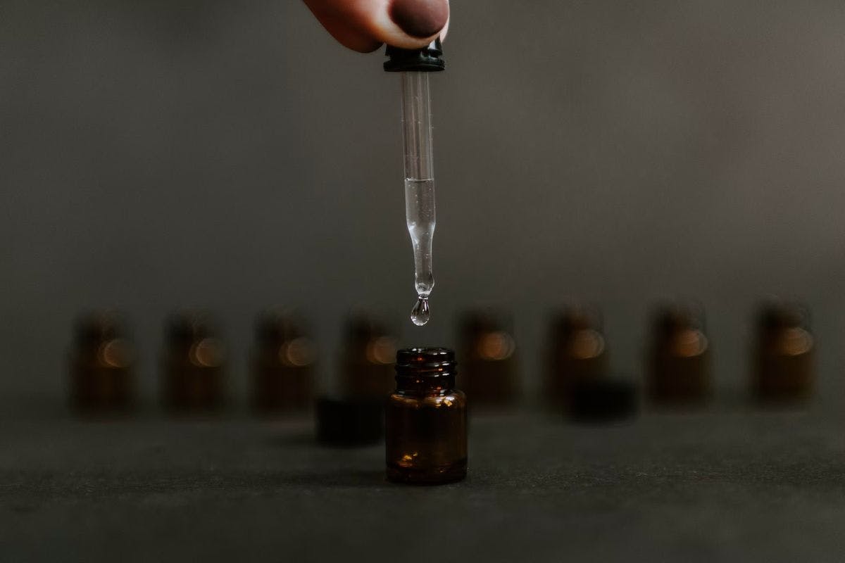 A row of medicine bottles and an eyedropper, by Kelly Sikkema via Unsplash