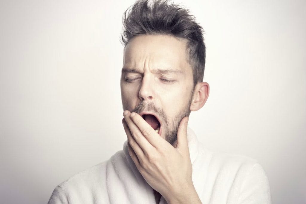 A man yawns, desiring sleep? By Sammy Williams via Unsplash