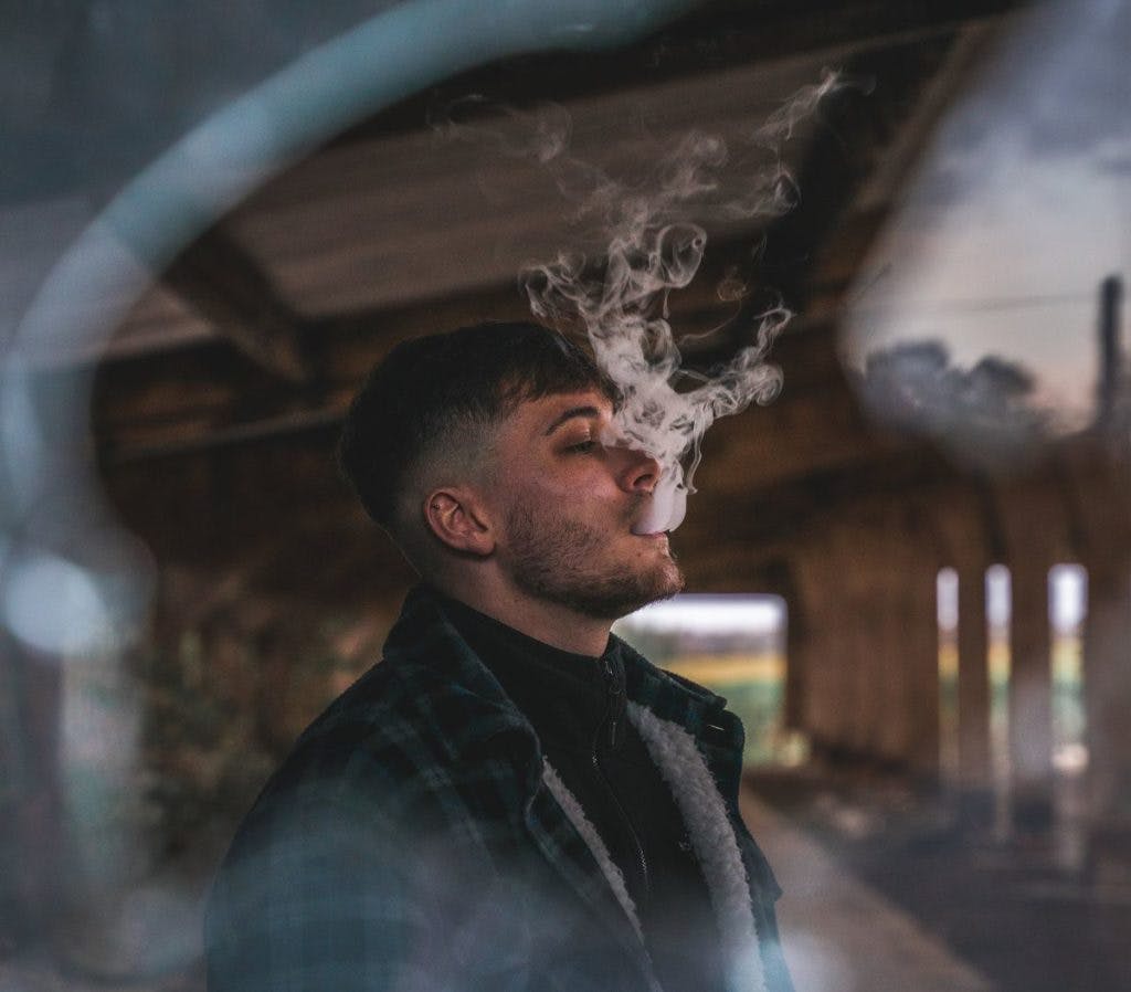 A man exhales a cloud of vapor, by Connor-Danylenko via Pexels