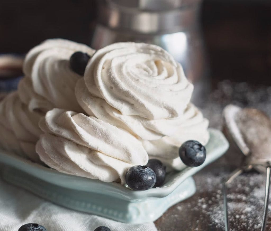 A pile of whipped cream and fresh blueberries, by Dilyara Garifullina via Unsplash