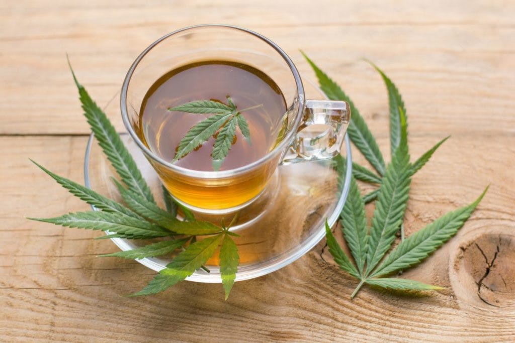 A cup of cannabis tea, with leaves as a garnish, by vlbentley via iStock