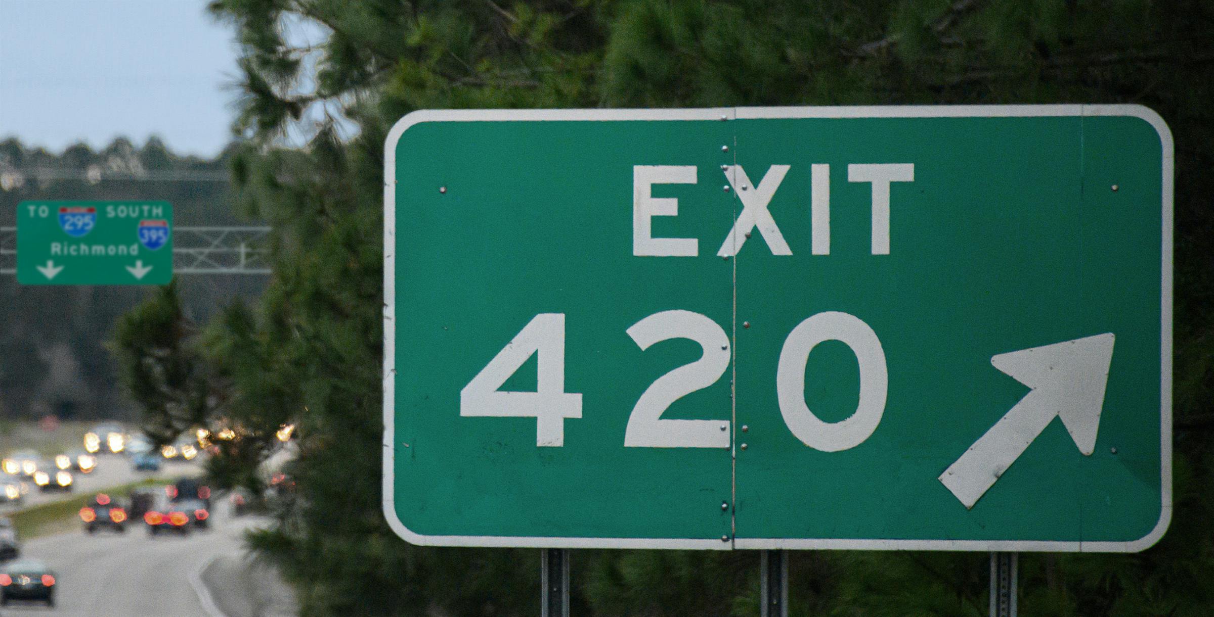 A freeway sign reads "exit 420" while there is a sign in the background that says Richmond